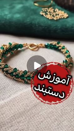 a bracelet with green beads and gold chains on top of a white cloth covered table