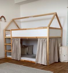 there is a bunk bed with curtains on the top and bottom floor, next to a rug