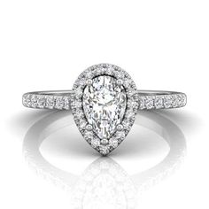 a pear shaped diamond engagement ring on a white background