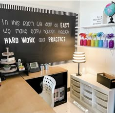 an office with a chalkboard on the wall that says hard work and practice