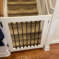 an open door leading to a set of stairs in a home with wood floors and white railings