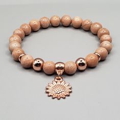 "Quality, Genuine, Real Natural sunstone bracelet with rose gold color spacers.. Made with a very strong, sturdy stretch cord and a cute rose gold plated sunflower charm.. This healing crystal bracelet has 8mm beads Size : 6.5 inch long, fits a wrist size 6 inch..If you like a different size, contact me and I will be happy to make you one.. :) IMPORTANT: Please make sure you measure your wrist as the picture show above to make sure it fits.. Meaning : Sunstone brings you the brightness of the su Sunstone Meaning, Sunstone Bracelet, Sunflower Charm, Bracelets Crystal, Bracelet Keychains, Cute Rose, Crystal Healing Bracelets, Diffuser Bracelets, Beaded Bracelets Diy