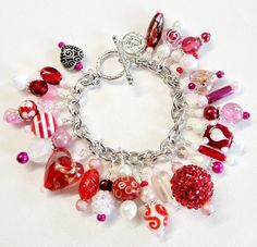 Make a statement with this beautiful bracelet. Silver wire wrapped freshwater pearls, glass pearls, cut Swarovski crystals, Czech glass, metal findings, and assorted glass beads are hung on a stainless-steel chain and finished with a large toggle clasp.  This bright and colorful beaded charm bracelet comes with a variety of the charms shown with one on every chain link on the bracelet from end to end.  The bracelet length shown measures 7 inches and can be adjusted as requested and clasp can be changed to a large lobster clasp if requested prior to shipping. Please measure your wrist to insure a proper fit, prior to purchase.  All beads are wire wrapped by me with great attention to detail. Bead size, shape, and color composition may vary from picture slightly, making your bracelet unique Heart-shaped Charms Beaded Bracelets For Jewelry Making, Handmade Metal Charm Bracelet For Valentine's Day, Valentine's Day Bracelets With Charms, Valentine's Day Beaded Charm Bracelet, Handmade Charm Bracelet For Valentine's Day, Valentine's Day Metal Charm Bracelet With Heart Beads, Handmade Charm Bracelet With Round Beads For Valentine's Day, Valentine's Day Heart Bracelet With Charms For Jewelry Making, Chunky Charm Bracelet