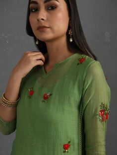 A straight-cut kurta in cotton silk fabric with all-over floral buttis made using A straight-cut kurta in cotton silk fabric with all-over floral buttis made using beads, sequins and silk French knots. Kurta, pants and dupatta have a lace edging at the hem, side cut, and sleeve ends. Bead work runs along the neckline and in between lace patterns. Delicate pin tucks stitched across the organza dupatta with embroidered scalloped edges and machine stitches in between pin tucks. Elasticated waist co