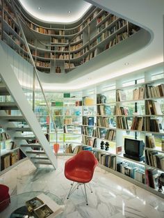 a room filled with lots of books next to a spiral staircase