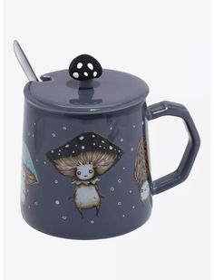 a ceramic teapot with an owl and mushroom design on the lid, sitting next to a spoon