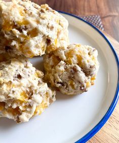 three biscuits on a white plate with blue trim