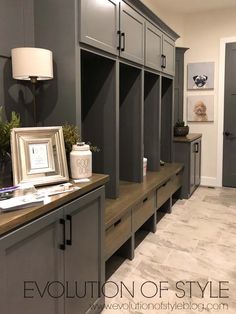 a room filled with lots of gray cupboards and drawers next to a white lamp