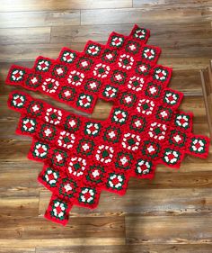 two red rugs with white and green flowers on them sitting on a wooden floor