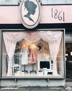 an old fashion store front with mannequins and dresses on display in the window