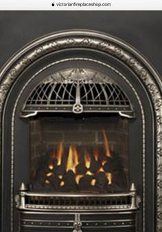 an ornate fireplace with fire burning in it