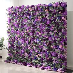 purple flowers are growing on the side of a wall in an office building with white walls