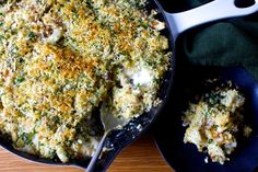 a casserole dish with broccoli and cheese in it next to a serving spoon