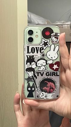 a woman holding up her phone case with stickers on the front and back of it