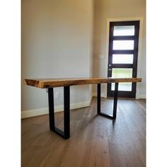 a wooden bench sitting in front of a door on top of a hard wood floor