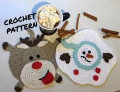 two crocheted reindeer coasters sitting next to a bowl of marshmallows