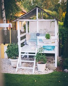 a white gazebo sitting on top of a lush green field