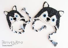 two crocheted hats with blue eyes are shown on a white surface, one has a raccoon ear flap and the other has a tassel