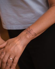 two people holding hands with tattoos on their arms and wrist, one has a flower tattoo on it's left arm