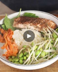 a bowl filled with rice, peas and meat on top of a wooden cutting board