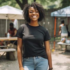 a woman standing in front of a picnic table with an umbrella behind her smiling at the camera