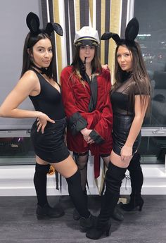 three women in bunny ears are posing for the camera while one woman is wearing a costume