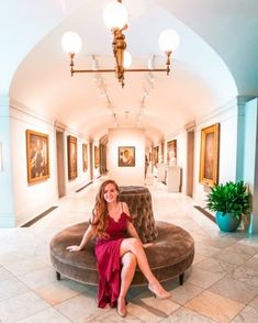 a woman in a red dress is sitting on a couch