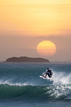 a man riding a wave on top of a surfboard in the middle of the ocean