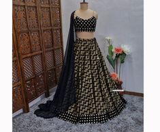 Made to Order/Measurement/Custom Order Lehenga - Color : Black - Fabric : Chevron Khadi Silk - Flared Paneled Lehenga skirt with Black Velvet Faux Mirror Border - Black Velvet Faux Mirror Spaghetti Blouse - Black dupatta with Fringes  - Drawstring closure with designer latkan - Can can attached PLEASE NOTE: BUYERS ARE RESPONSIBLE FOR ANY CUSTOMS AND IMPORT TAXES THAT MAY APPLY. Fabric Care : Dry Clean Only Disclaimer: Please note the photographs are taken by mobile camera in sunlight The actual color of the product might slightly differ due to exposure of light or monitor's display Shipping: This is made to order product. We customize the pattern of the dress to suit your style and fitting. Once you place the order we will provide you with a template for measurements (to be taken in inches Black Sets For Diwali Reception, Black Reception Set For Diwali, Black Anarkali Fitted Choli, Black Floor-length Designer Lehenga, Black Floor-length Sets For Navratri, Black Fitted Anarkali Choli, Floor-length Black Sets For Navratri, Fitted Black Anarkali Choli, Black Fitted Bollywood Lehenga