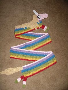 two crocheted scarfs laying on the floor next to each other, one with an animal's head sticking out of it