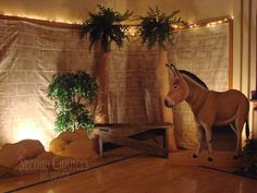 a fake horse is standing in front of a wall with plants and lights on it