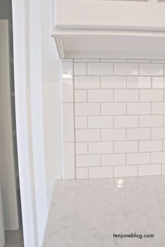 a kitchen counter with white tile on it