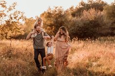 a group of people standing in a field with one holding the other's hand