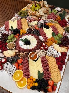 a table topped with lots of different types of cheeses and fruit on top of it