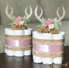 two napkins decorated with flowers and antlers are sitting on a table