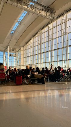 people are sitting in the waiting area at an airport