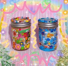 two jars with buttons on them sitting next to each other in front of a colorful background