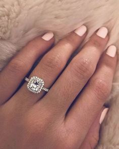 a woman's hand with a diamond ring on it