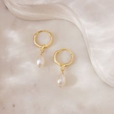 Love a finishing touch that's classic and summery? We've got just the thing. These earrings are crafted from freshwater pearls and dangle from gold-plated continuous hoops. Worn alone, the huggie style is perfect for adding a minimalistic touch to any warm-weather outfit. For extra summery, extra mermaid-y vibes, try pairing these pearl huggies with other pearl favorites, like the Pearl Classic Hoops or Pearl Chain Studs. Pearl Huggies, Warm Weather Outfits, The Pearl, Pearl Chain, The Thing, Christmas List, Love A, Warm Weather, Fresh Water