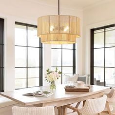 a dining room table with chairs and a chandelier hanging from it's ceiling