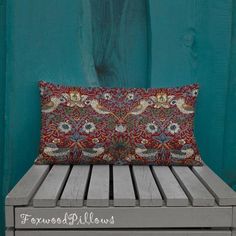 a pillow sitting on top of a wooden bench next to a green wall and wood planks