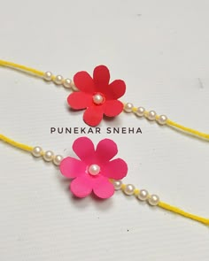 three different colored flowers and pearls on a string