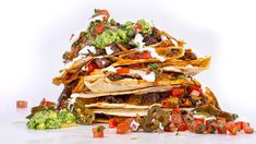 a stack of tortillas piled on top of each other with various toppings