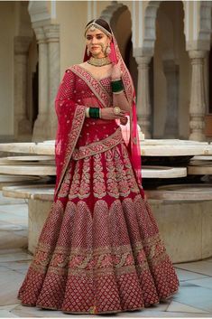 a woman in a red and gold bridal gown