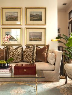 a living room filled with furniture and pictures on the wall above it's coffee table