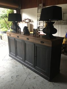 two lamps sitting on top of a wooden cabinet