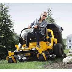 a man riding on the back of a yellow lawn mower