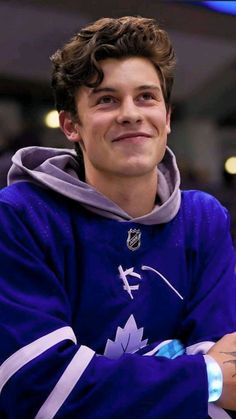 a young man with his arms crossed smiling