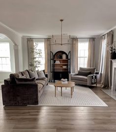 a living room filled with furniture and a fire place in the middle of a room