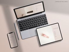 an open laptop computer sitting on top of a desk next to a phone and tablet